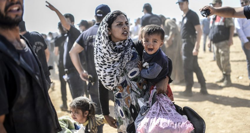 TOPSHOTS -- AFP PICTURES OF THE YEAR 2014 -- A Syrian Kurdish woman crosses the border between Syria and Turkey at the southeastern town of Suruc in Sanliurfa province on September 23, 2014. The UN refugee agency warned Tuesday that as many as 400,000 people may flee to Turkey from Syria's Kurdish region to escape attacks by the Islamic State group.  AFP PHOTO / BULENT KILICBULENT KILIC/AFP/Getty Images ORG XMIT: