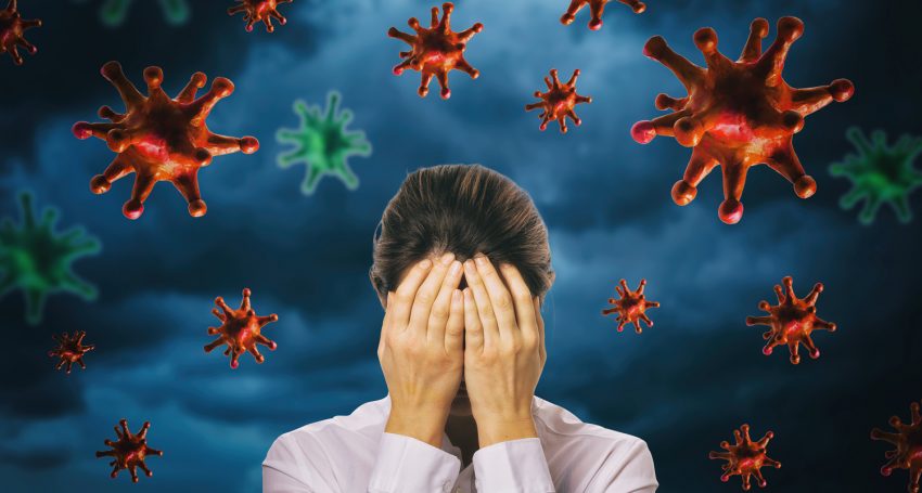The girl closed her face with her hands against the background of a thunderstorm sky with a coronavirus. The concept of fear of the pandemic COVID-19