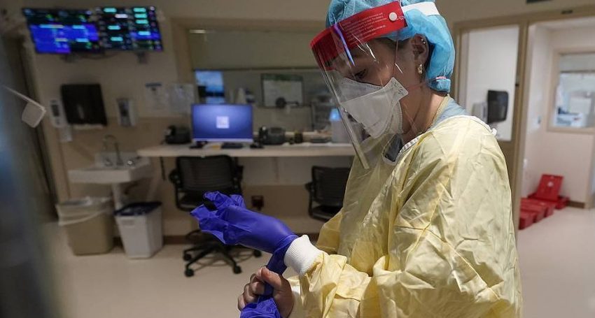 Registered nurse Sara Nystrom, of Townshend, Vt., puts on protective gear in the COVID-19 Intensive Care Unit at Dartmouth-Hitchcock Medical Center, in Lebanon, N.H., Monday, Jan. 3, 2022. (AP Photo/Steven Senne)